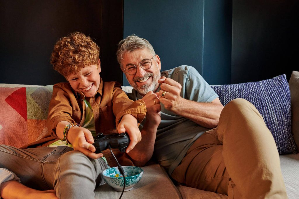 Gamig ist ein Hobby für alle Junge und Opa spielen zusammen ein Videospiel